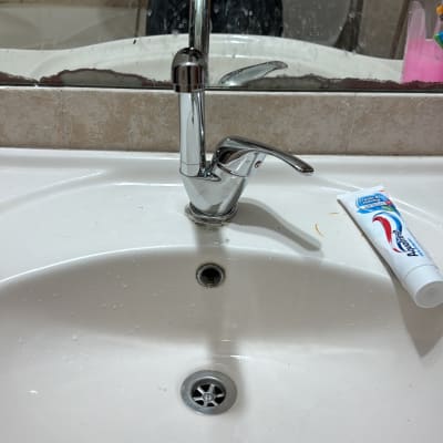 ברז כיור עם משחת שיניים על השיש