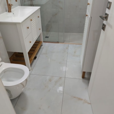 חדר אמבטיה נקי עם רצפה מבריקה וכיור לבן