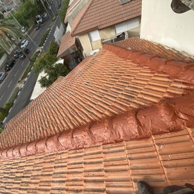גג רעפים אדום עם חומר איטום לאורך החיבורים