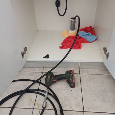 כלי עבודה וצינור מתחת לכיור