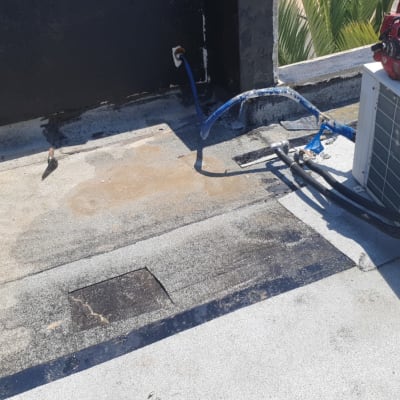 צינורות כחולים ושחורים ליד יחידת מיזוג אוויר