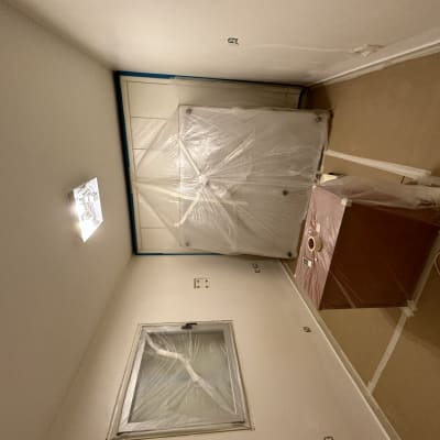 חדר עם רהיטים מכוסים בניילון לקראת צביעה