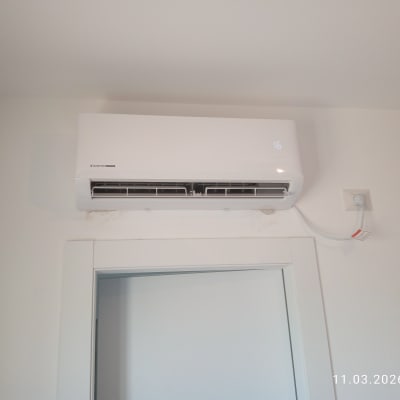 מזגן מותקן על קיר מעל דלת עם תאריך ושעה בתחתית התמונה