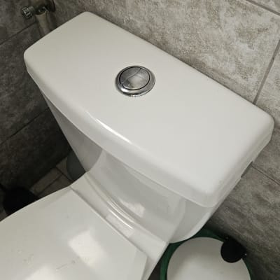 אסלה לבנה בחדר אמבטיה עם קיר אריחים אפור