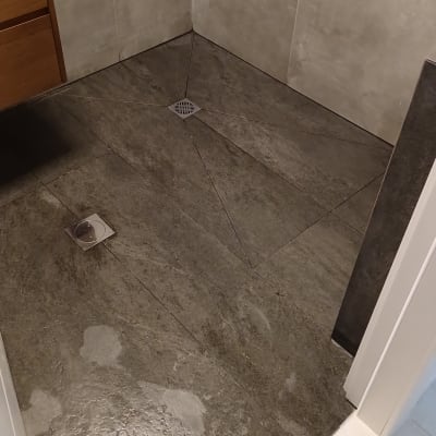 רצפת מקלחת עם אריחים כהים וניקוז