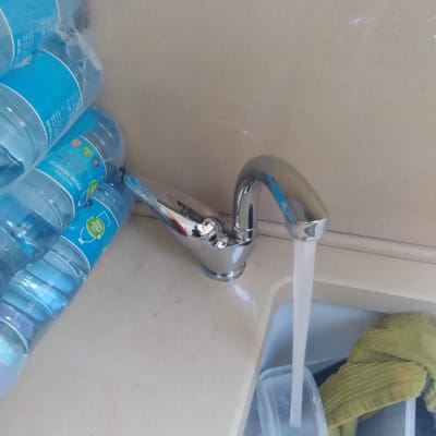 ברז מים זורם בכיור עם כלים