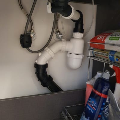 צנרת מתחת לכיור עם מחברים וברזים