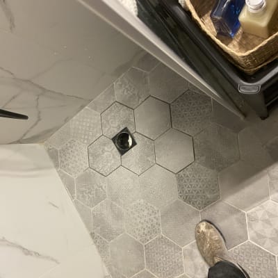 רצפת אריחים עם חור פתוח לצנרת אינסטלציה