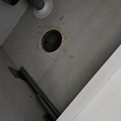 צינור ביוב מתחת לכיור עם חור בקיר