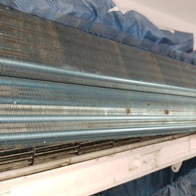 סליל מתכת של מזגן עם לכלוך ואבק