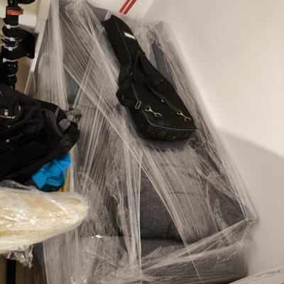 ספה עטופה בניילון עם תיק מונח עליה