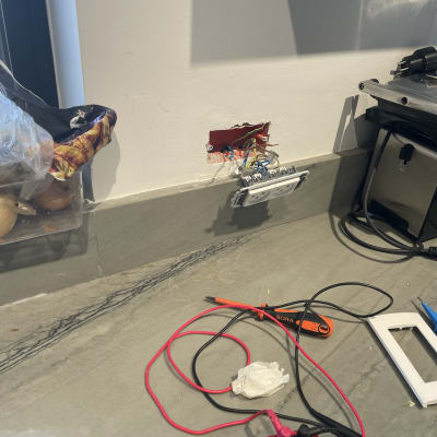 שקע חשמלי פתוח עם חוטים וכלי עבודה על השיש