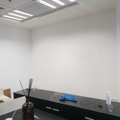 קיר לבן עם פחית צבע וכפפה על שולחן