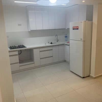 מטבח מודרני עם ארונות לבנים ומקרר היטאצ