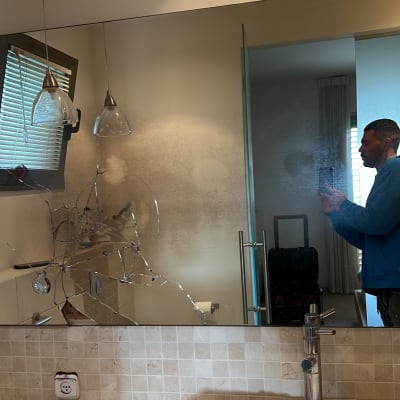 מראה שבורה עם סדקים רבים בחדר אמבטיה