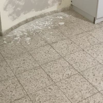 קיר עם טיח מתקלף ורצפה עם שאריות צבע