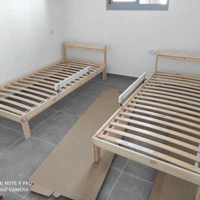 שתי מיטות עץ עם מסגרות מתכת בחדר