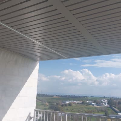 פרגולה מאלומיניום עם קורות אופקיות על מרפסת