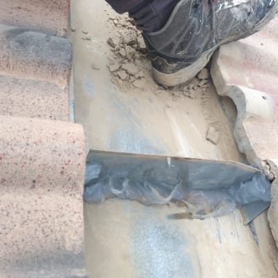 תיקון גג עם חומר איטום בין רעפים שבורים