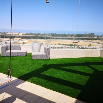 דשא סינתטי על מרפסת עם עציץ ריק