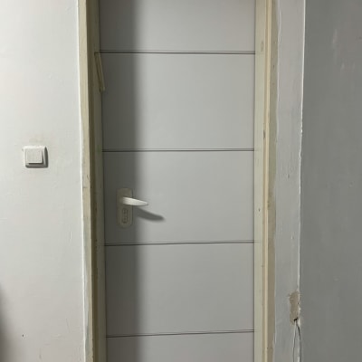 דלת לבנה עם ידית לבנה במסגרת קיר