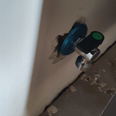 ברז מים מותקן בקיר עם חור מסביב