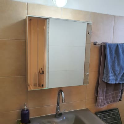 מראה זכוכית מעל כיור בחדר אמבטיה