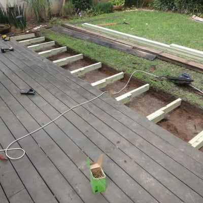 בניית דק עץ בגינה עם קורות עץ וכלים