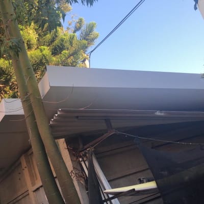 גג מתכת עם קורות תומכות ועצים מסביב