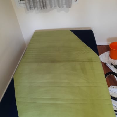 ספה ירוקה עם סימני ניקוי, דלי כתום בצד