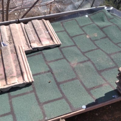 רעפים ישנים על גג ירוק עם ברגים