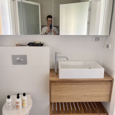 כיור וברז בחדר אמבטיה מודרני עם ארון עץ