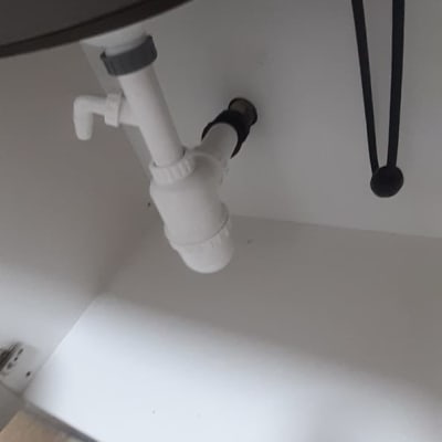 צנרת לבנה מתחת לכיור עם ברזים