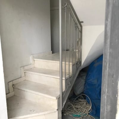 מעקה מתכת אפור על מדרגות לבנות