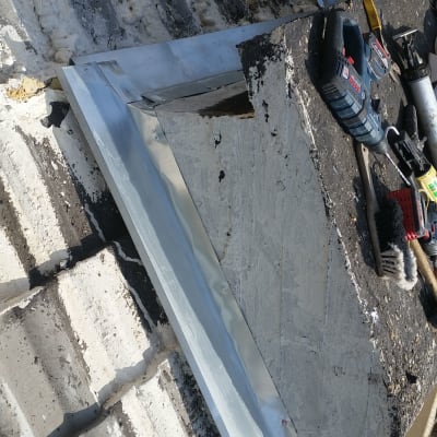 גג עם לוחות מתכת וכלי עבודה שונים