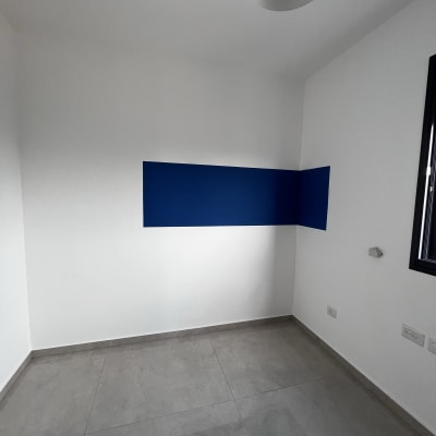 קיר צבוע בפס כחול בחדר לבן