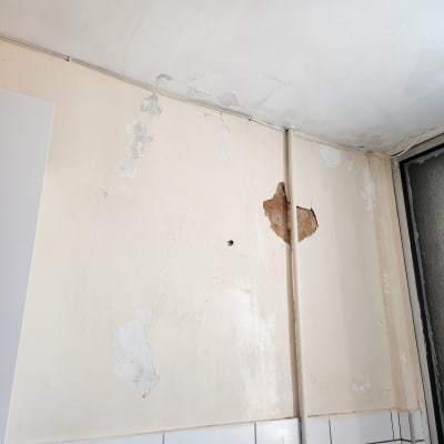 קיר עם קילופי צבע ותיקוני טיח