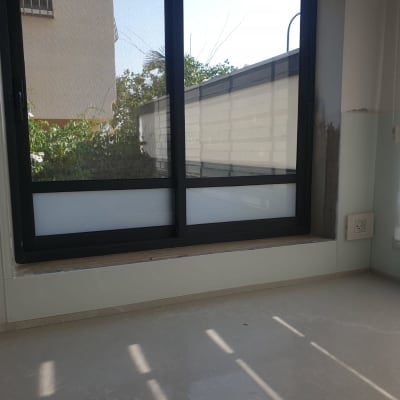 חלון זכוכית עם מסגרת שחורה ותריסים