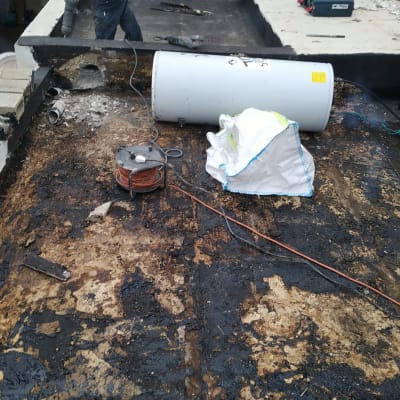 עובד עם כלי עבודה על גג לאיטום