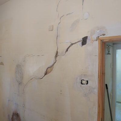 קיר עם סדקים ותיקוני טיח לקראת צביעה