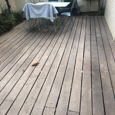 רצפת עץ בגינה עם שולחן וכיסאות מתכת