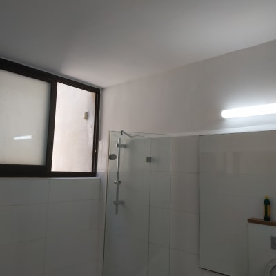 תקרה וקיר צבועים בלבן עם תאורה עליונה