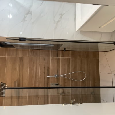 מקלחון עם דלת זכוכית ומגב לניקוי