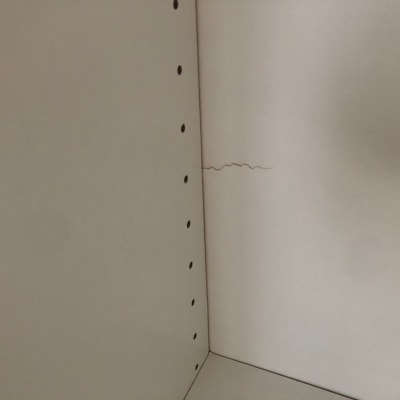 סדק בקיר לבן עם חורים בצד