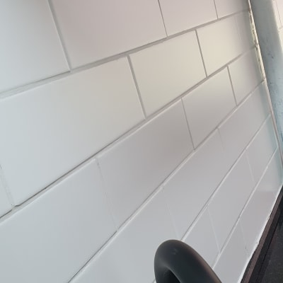 קיר אריחים לבנים עם ידית שחורה