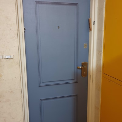 דלת כחולה עם ידית מתכת ומסגרת לבנה