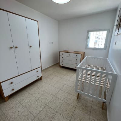 רצפת אריחים בחדר ילדים עם רהיטים לבנים