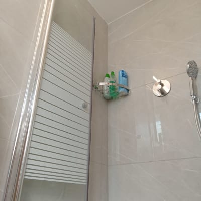 מקלחון עם דלת זכוכית ומדף מתכת