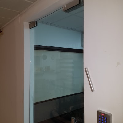 מערכת אינטרקום עם לוח מקשים ליד דלת זכוכית