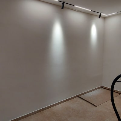 קיר צבוע בלבן עם דלי צבע ומטאטא